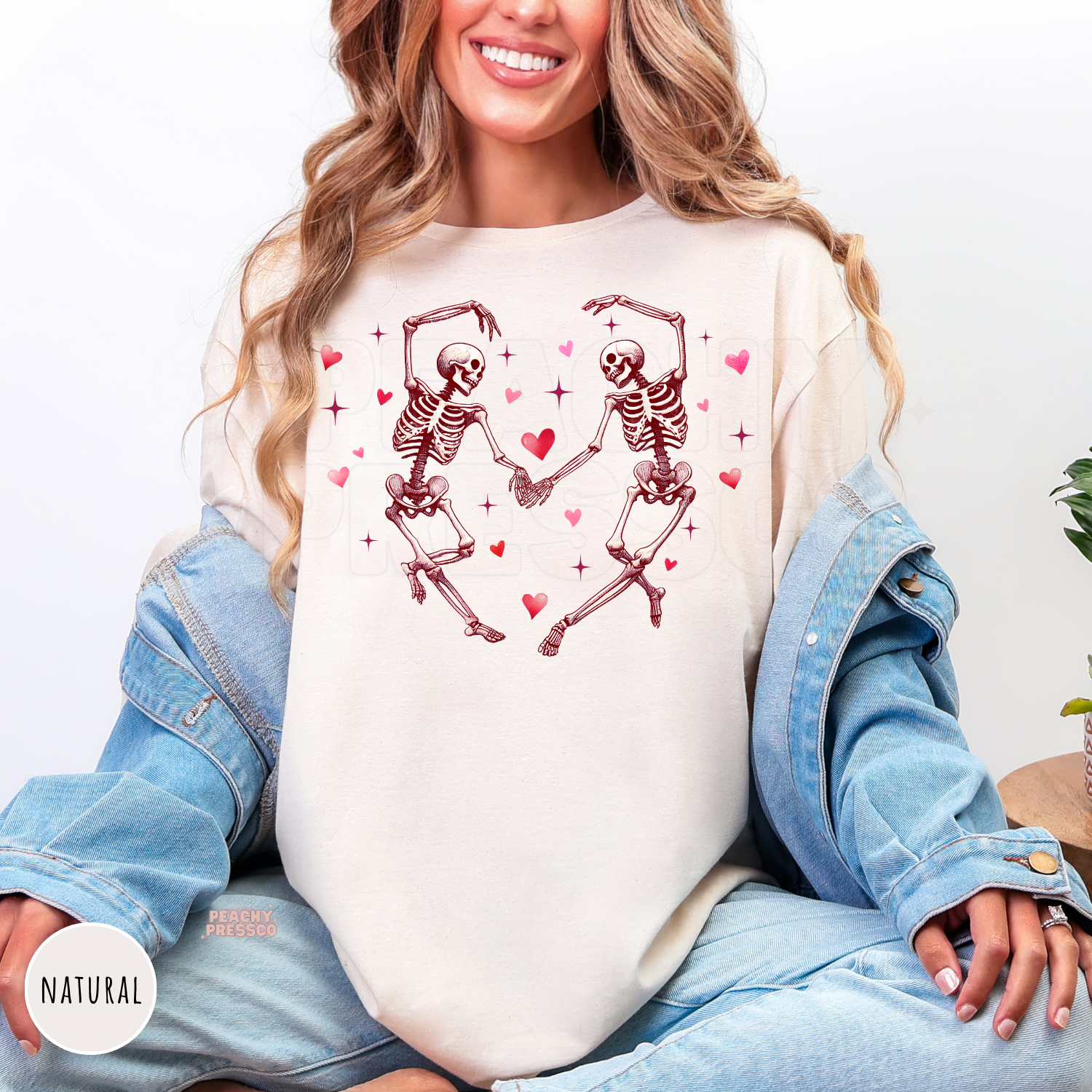 Natural shirt featuring two dancing skeletons holding hands with pink hearts in a cute gothic Valentine's Day design.