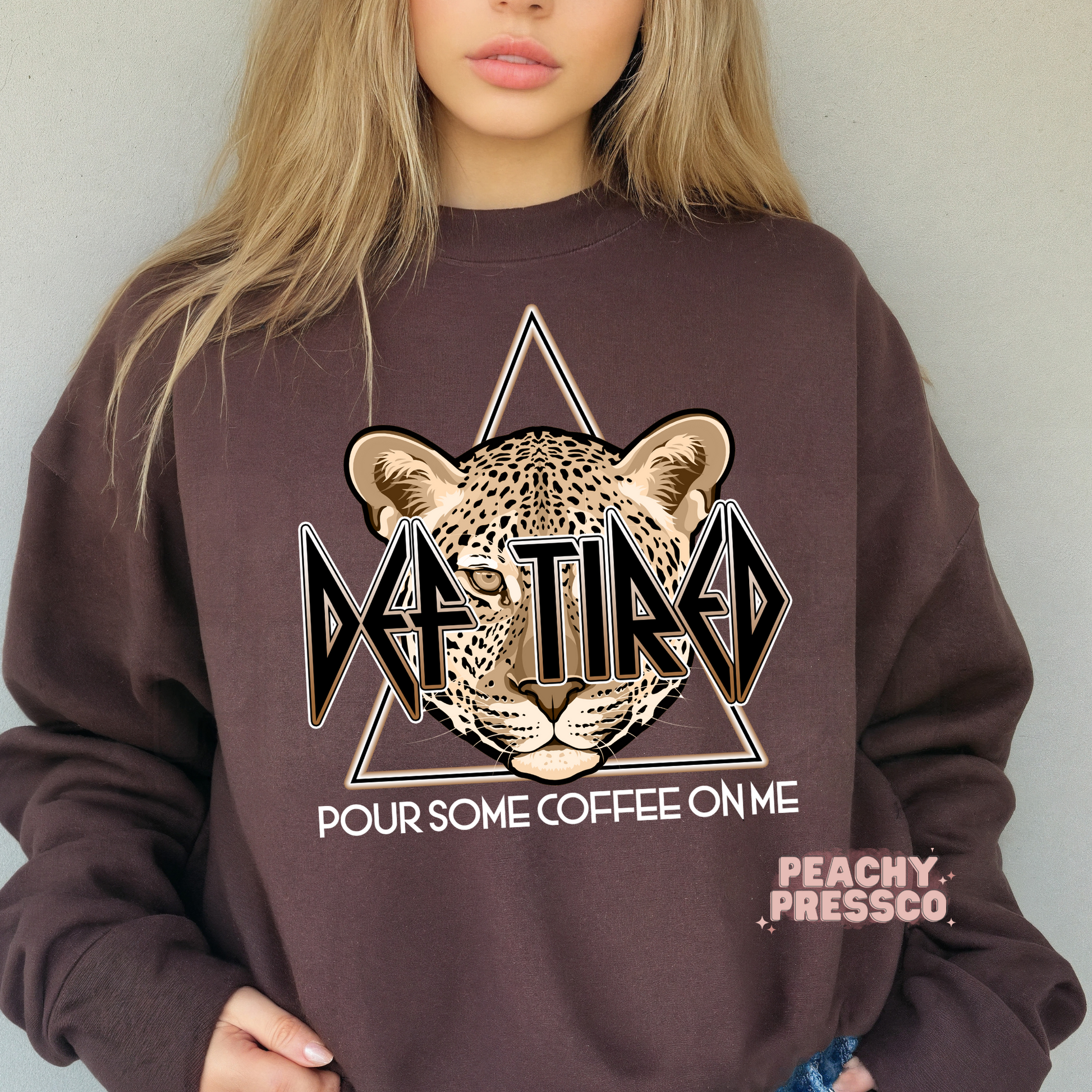 Dark brown Def Tired Pour Some Coffee On Me sweatshirt featuring a leopard face with a retro rock-inspired graphic, perfect for coffee lovers, caffeine addicts, and cozy everyday wear.