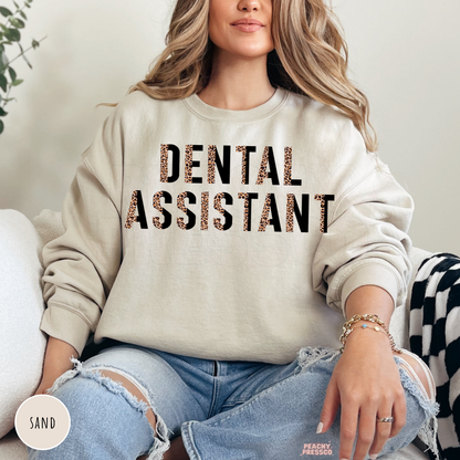 Sand crewneck sweatshirt with a leopard print Dental Assistant graphic, a cozy gift for dental assistants, dental hygienists, and dental office teams.