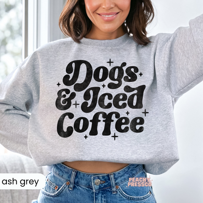 Woman wearing an ash grey cropped sweatshirt with a distressed "Dogs & Iced Coffee" graphic.