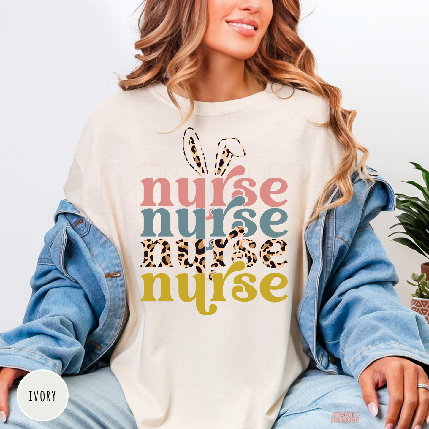 Woman wearing an ivory Comfort Colors t-shirt with a retro Easter Nurse graphic featuring bunny ears and pastel leopard print typography.