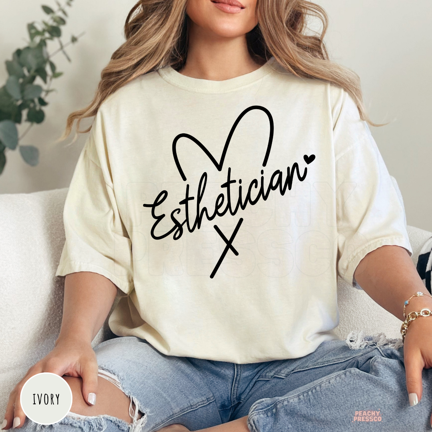 Ivory unisex t-shirt featuring a minimalist Esthetician heart design in black script, ideal for estheticians, facial specialists, and spa workers.