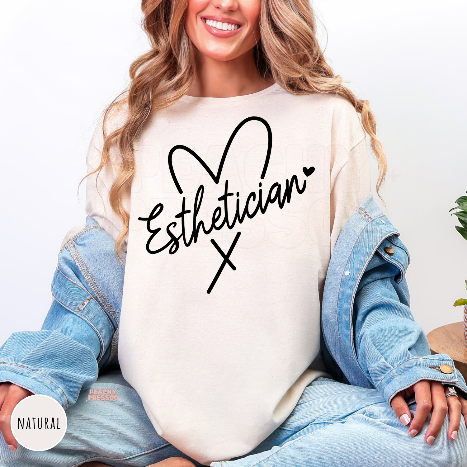 Natural shirt with elegant Esthetician script inside a heart outline, a stylish gift for licensed estheticians and skincare professionals.