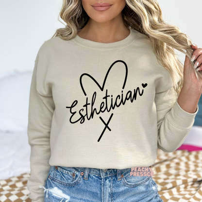 Sand-colored crewneck sweatshirt with a minimalist Esthetician heart script design, a comfortable everyday sweatshirt for estheticians and beauty professionals.