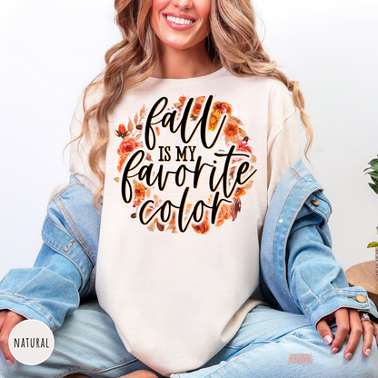 Woman wearing a natural graphic t-shirt with the phrase "Fall Is My Favorite Color" surrounded by a beautiful autumn floral wreath.