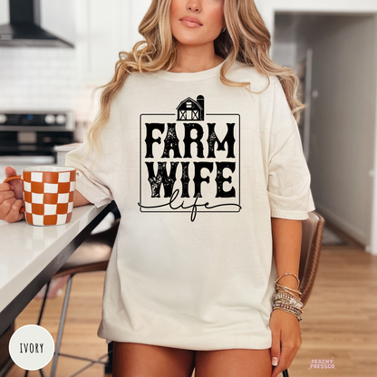 Woman wearing an ivory Farm Wife Life graphic t-shirt featuring a distressed farmhouse design in a modern western country style.
