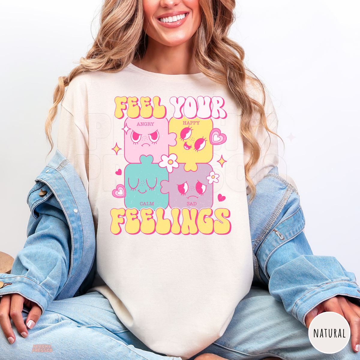 Natural Feel Your Feelings shirt featuring colourful pink, yellow, teal and purple puzzle characters expressing angry, happy, calm and sad emotions.