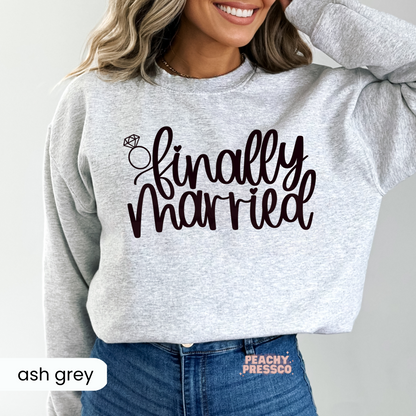Ash grey sweatshirt with a stylish "Finally Married" design and diamond ring graphic, perfect for newlywed couples, bridal celebrations, honeymoon trips, and everyday post-wedding wear.
