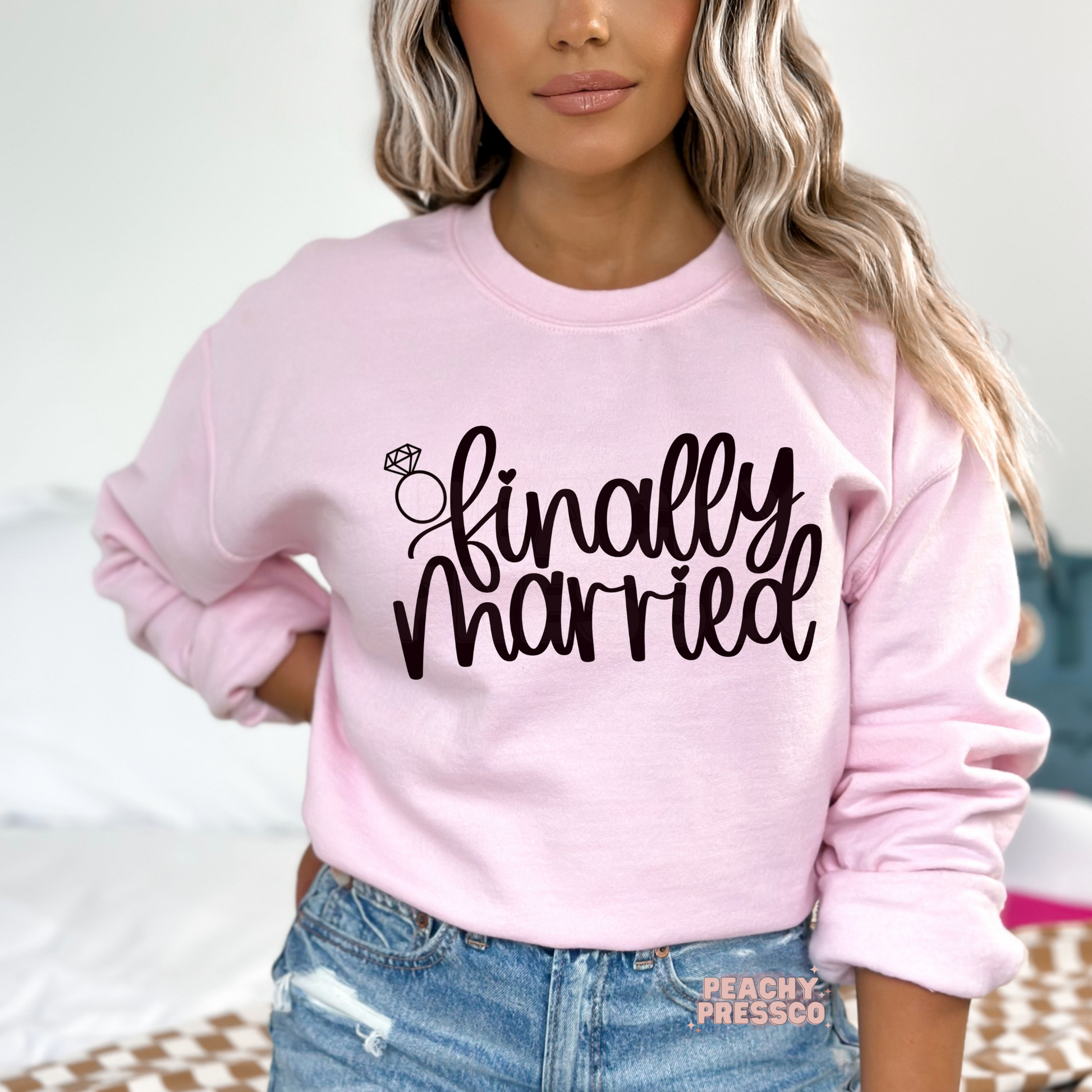 Light pink crewneck sweatshirt featuring the "Finally Married" graphic with a diamond ring illustration, perfect for newlyweds, honeymoon trips, post-wedding celebrations, bridal gifts, and wedding keepsakes.