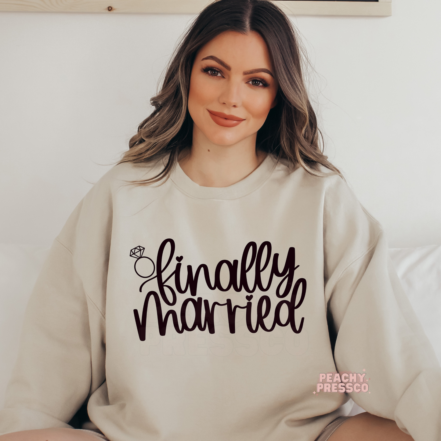 Sand crewneck sweatshirt featuring the "Finally Married" graphic with a diamond ring illustration, ideal for cozy honeymoon wear, wedding celebrations, and newlywed gifts.