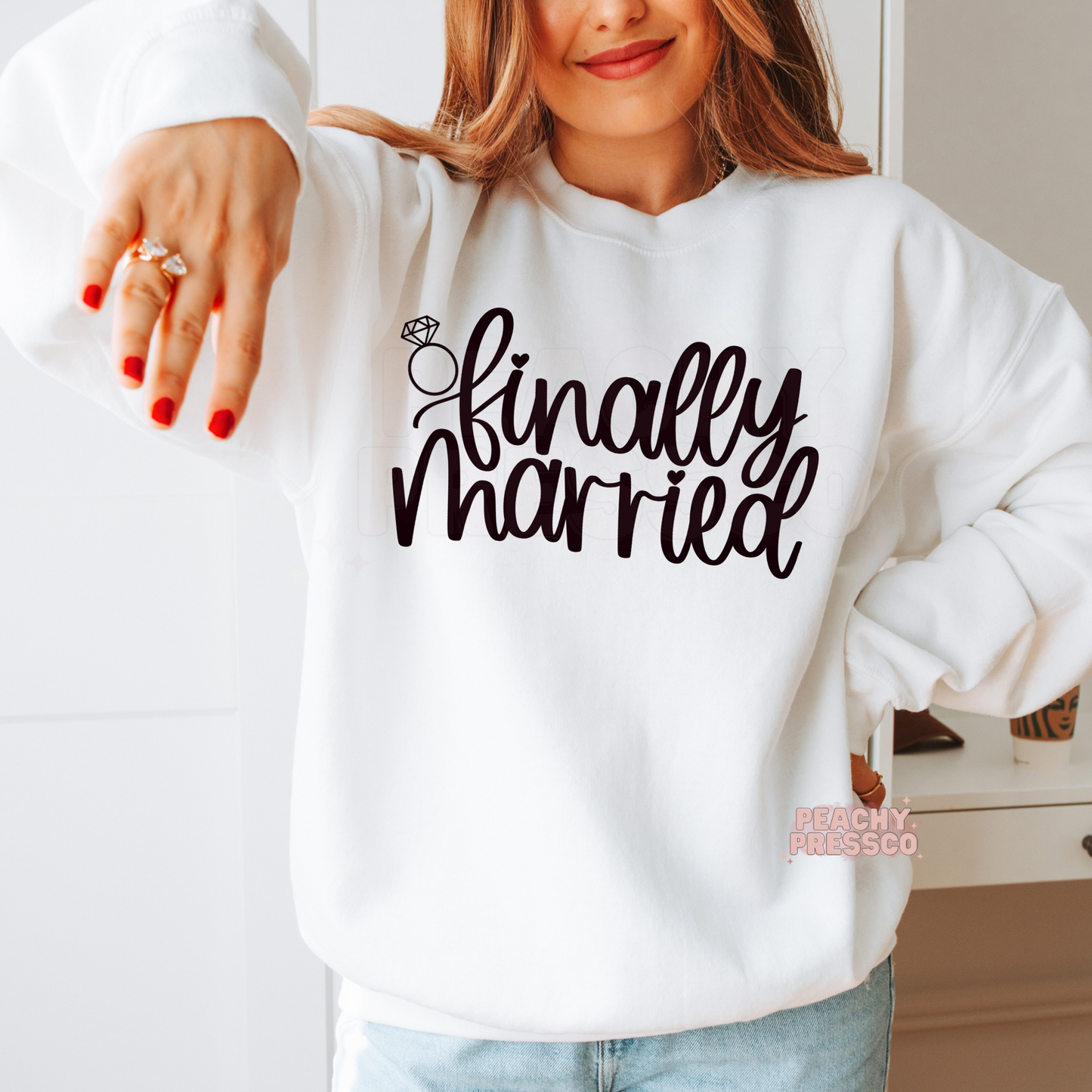 White crewneck sweatshirt featuring the "Finally Married" graphic with a diamond ring illustration, perfect for brides, honeymoon vacations, wedding celebrations, newlywed photos, and thoughtful bridal gifts.