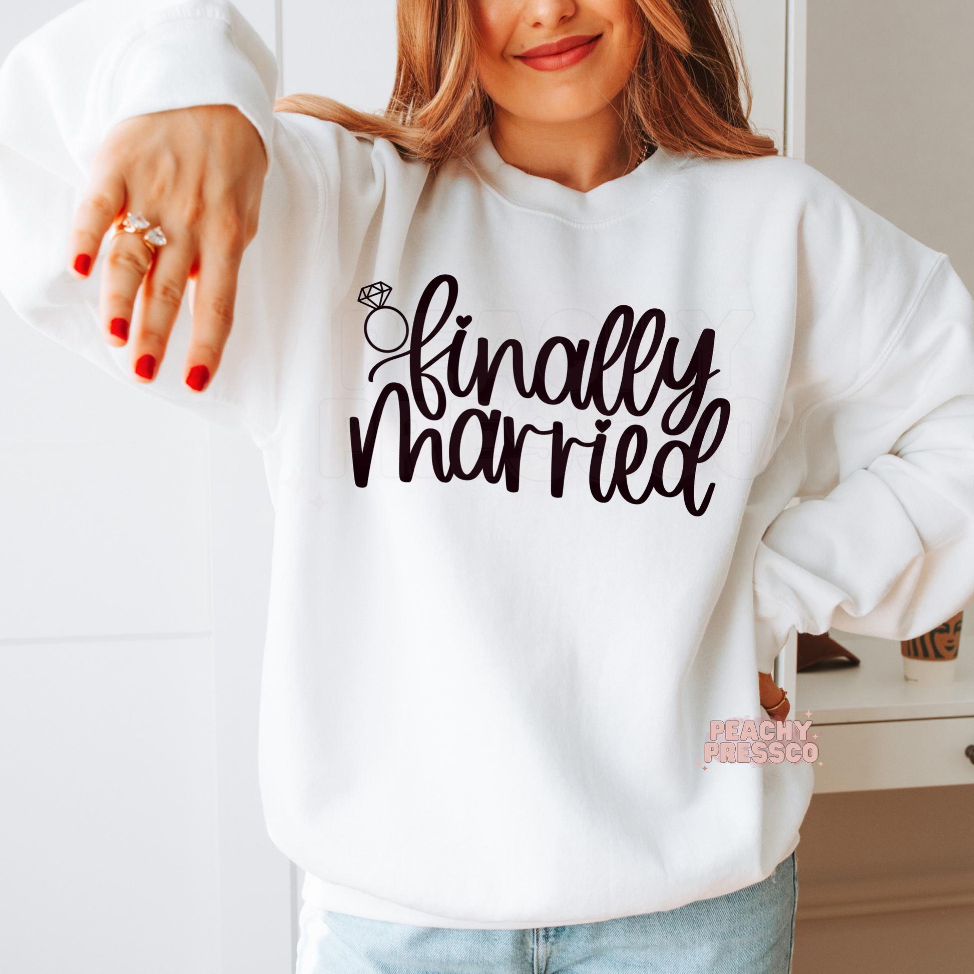 White crewneck sweatshirt featuring the "Finally Married" graphic with a diamond ring illustration, perfect for brides, honeymoon vacations, wedding celebrations, newlywed photos, and thoughtful bridal gifts.