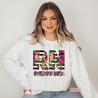 Woman wearing a white sweatshirt featuring a floral RN Registered Nurse graphic with a stethoscope design, perfect for nurse appreciation gifts.