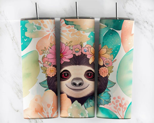 20 oz skinny tumbler featuring a smiling sloth wearing a colorful floral crown with soft watercolor tropical leaves. Includes clear lid and reusable straw.