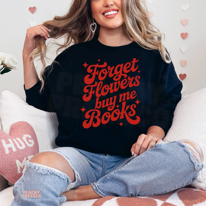 Black sweatshirt featuring the bold "Forget Flowers Buy Me Books" graphic in retro red lettering, perfect for book lovers.