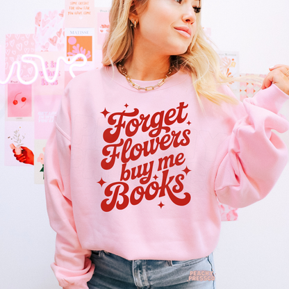 Light pink sweatshirt with the playful "Forget Flowers Buy Me Books" quote in vintage-inspired red typography for readers.