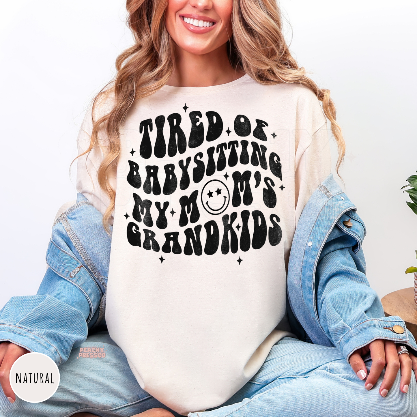 Natural shirt featuring the retro "Tired of Babysitting My Mom's Grandkids" graphic. Trendy funny mom crewneck perfect for Mother's Day or everyday wear.