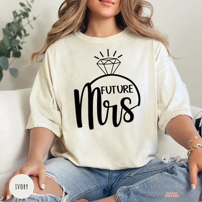 Ivory Comfort Colors t-shirt with a black "Future Mrs" graphic and diamond ring illustration, perfect for engaged women, bridal events, engagement photos, bachelorette weekends, and wedding gift ideas.
