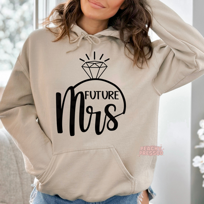 Sand pullover hoodie with a stylish "Future Mrs" graphic and diamond engagement ring design, perfect for brides-to-be, engagement gifts, wedding planning, honeymoon travel, and cozy bridal apparel.