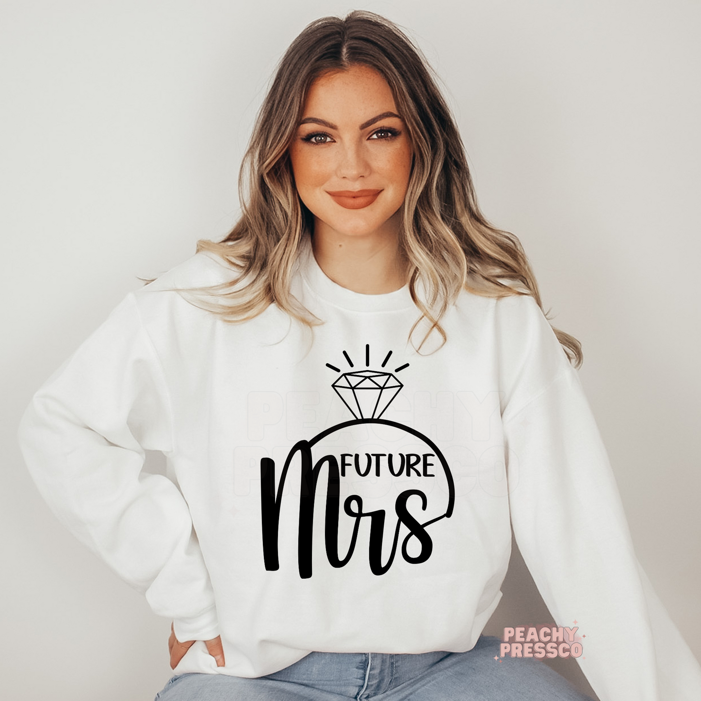 White crewneck sweatshirt featuring a stylish "Future Mrs" graphic with a diamond engagement ring design, perfect for brides-to-be, engagement announcements, bridal showers, bachelorette parties, wedding planning, and honeymoon gifts.