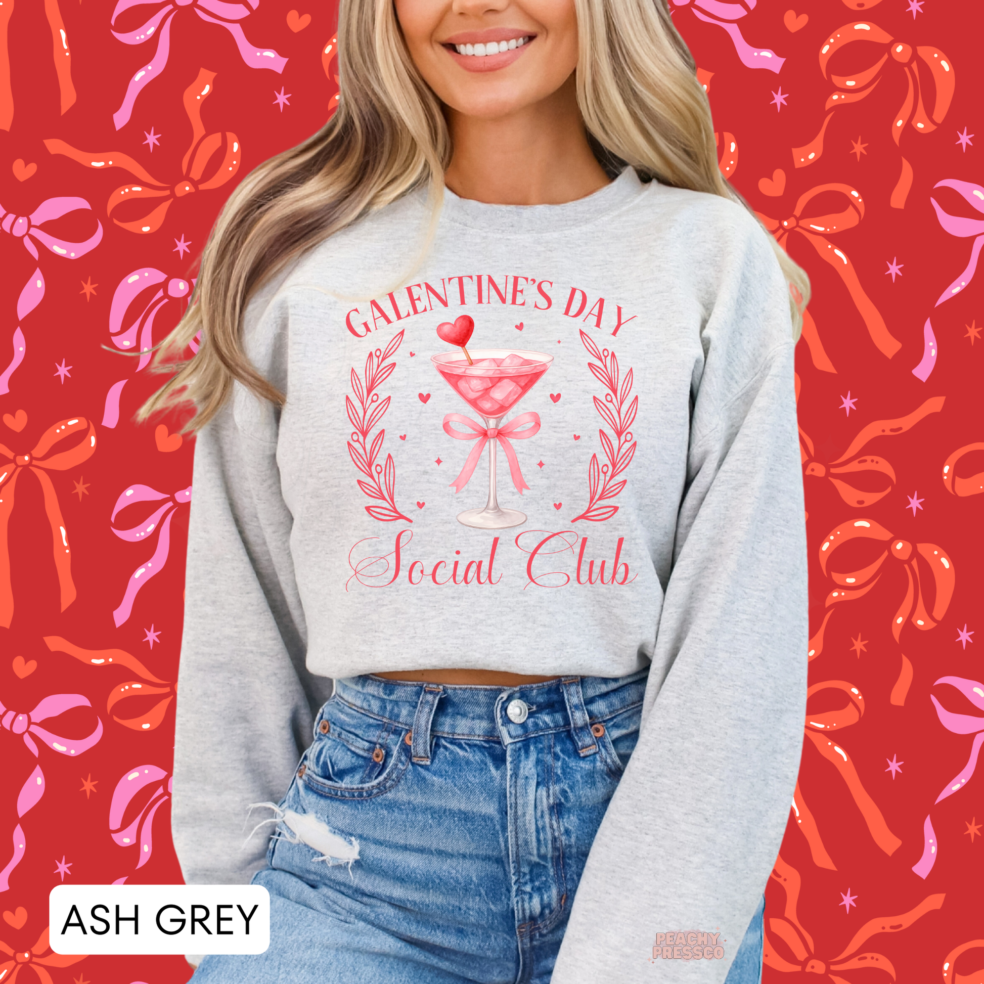 Ash grey sweatshirt featuring a Galentine's Day Social Club design with a pink martini glass, heart accents, ribbon bow, and girls' night aesthetic.