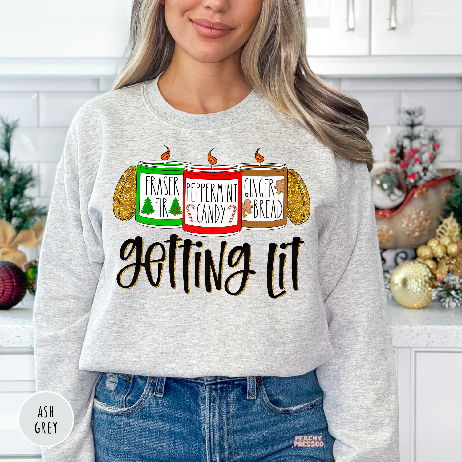 Woman wearing an ash grey holiday crewneck sweatshirt featuring three Christmas candles and Getting Lit text.