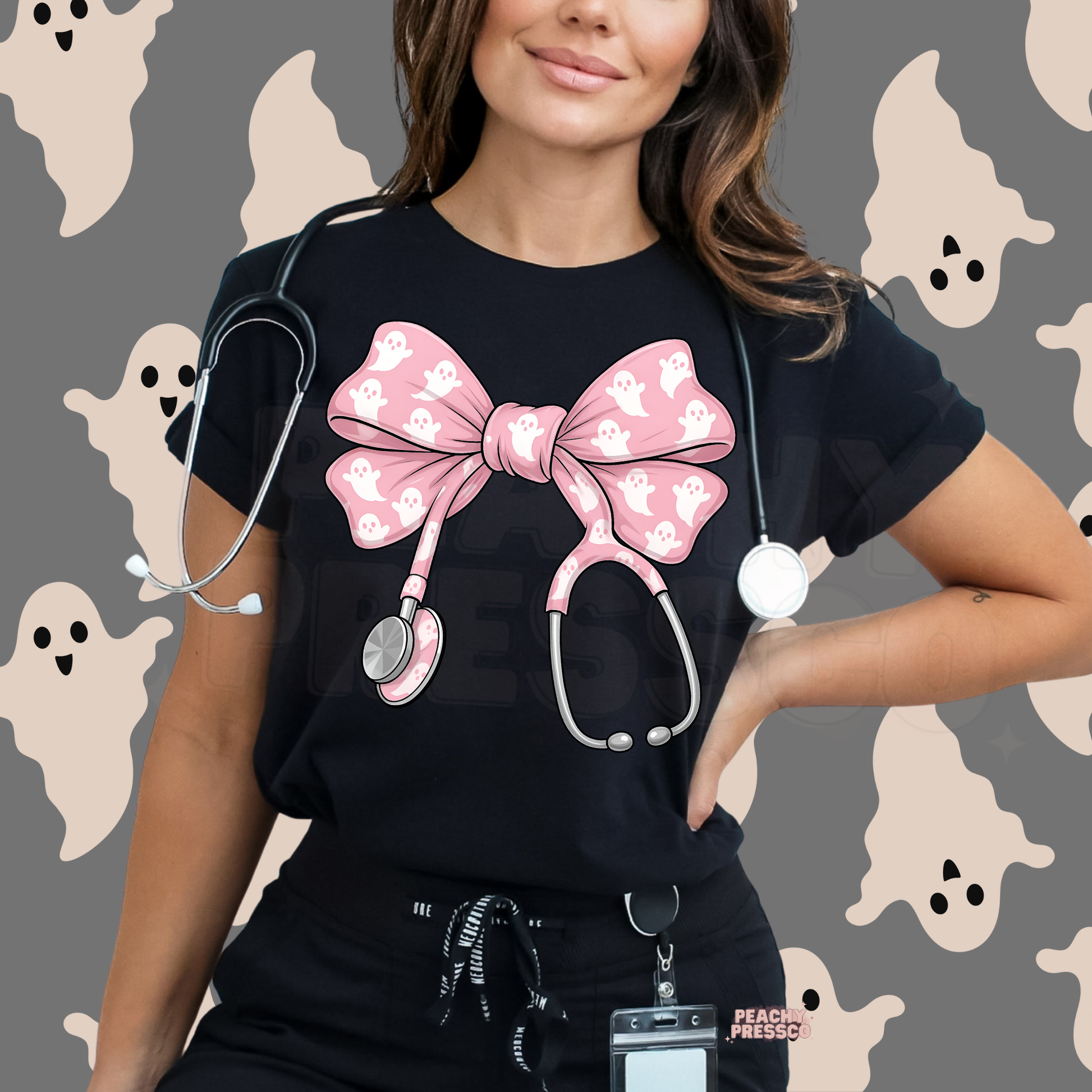 Healthcare worker wearing a black scrub top featuring a pink ghost stethoscope bow design, perfect for Halloween shifts and spooky season.