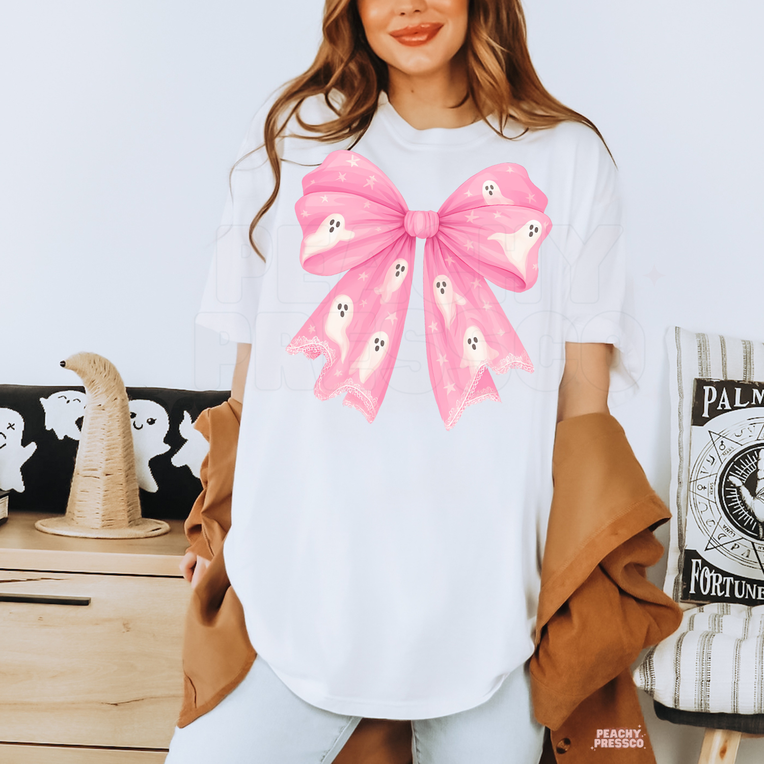 White Halloween graphic tee featuring an oversized pink bow with cute ghosts, stars and delicate lace details