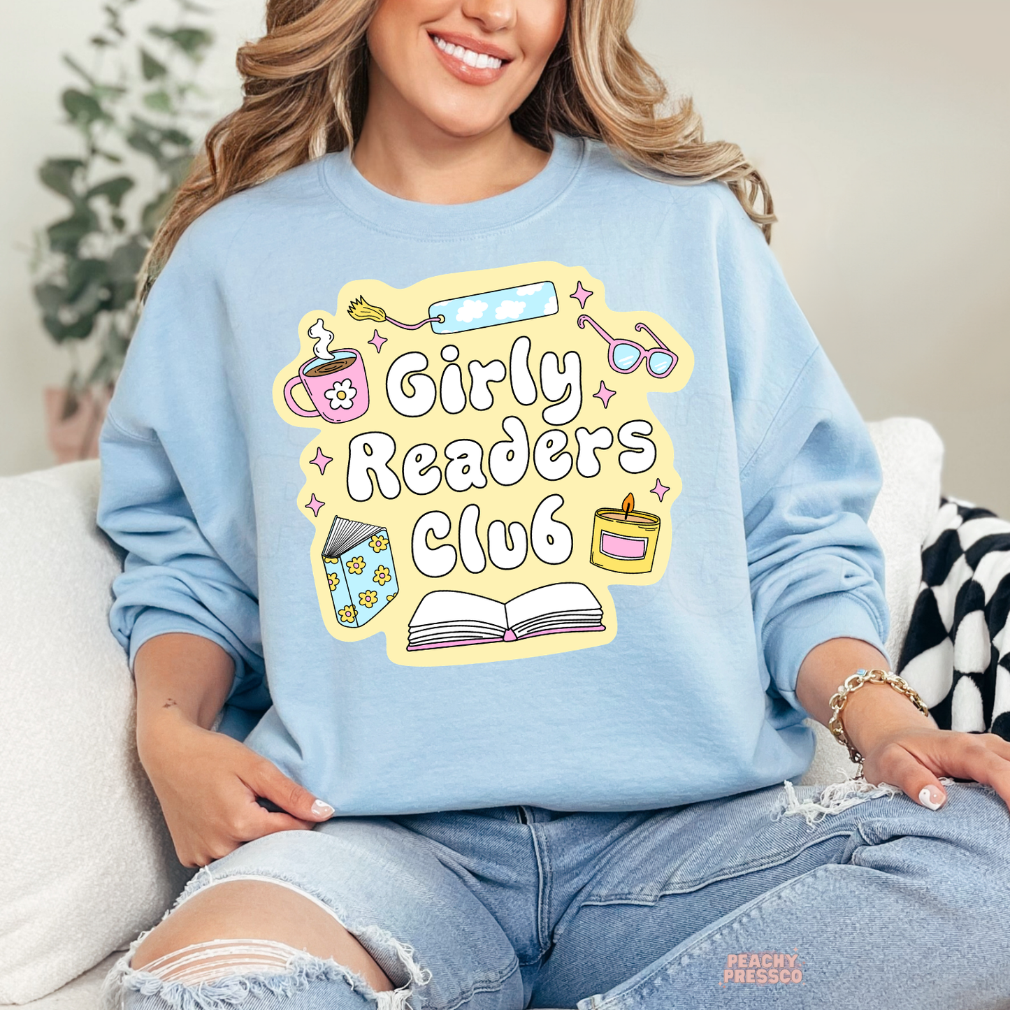 Light blue crewneck sweatshirt with Girly Readers Club design featuring coffee, books, bookmark, candle, and glasses.