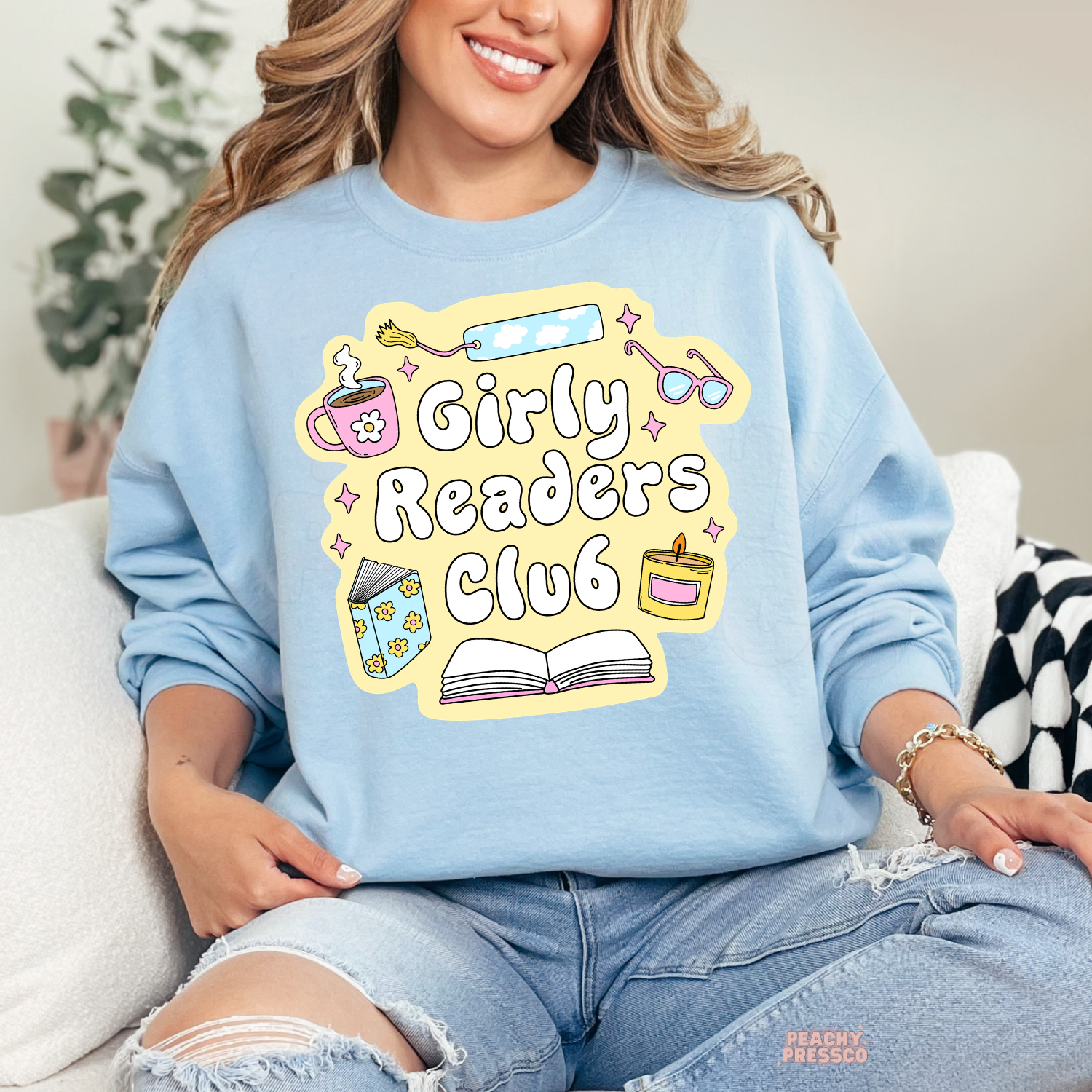 Light blue crewneck sweatshirt with Girly Readers Club design featuring coffee, books, bookmark, candle, and glasses.