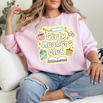 Light pink crewneck sweatshirt featuring the Girly Readers Club graphic with pastel bookish illustrations and cozy reading essentials.