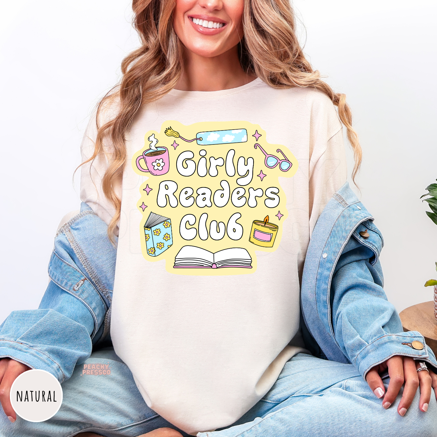 Natural unisex graphic tee featuring the Girly Readers Club design with books, coffee mug, candle, bookmark, and glasses for book lovers.