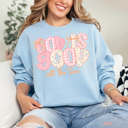 Light Blue Gildan crewneck sweatshirt featuring a pastel "God Is Good All The Time" design with pink gingham letters, floral accents, and bows. Cozy unisex Christian sweatshirt with a soft spring-inspired aesthetic.