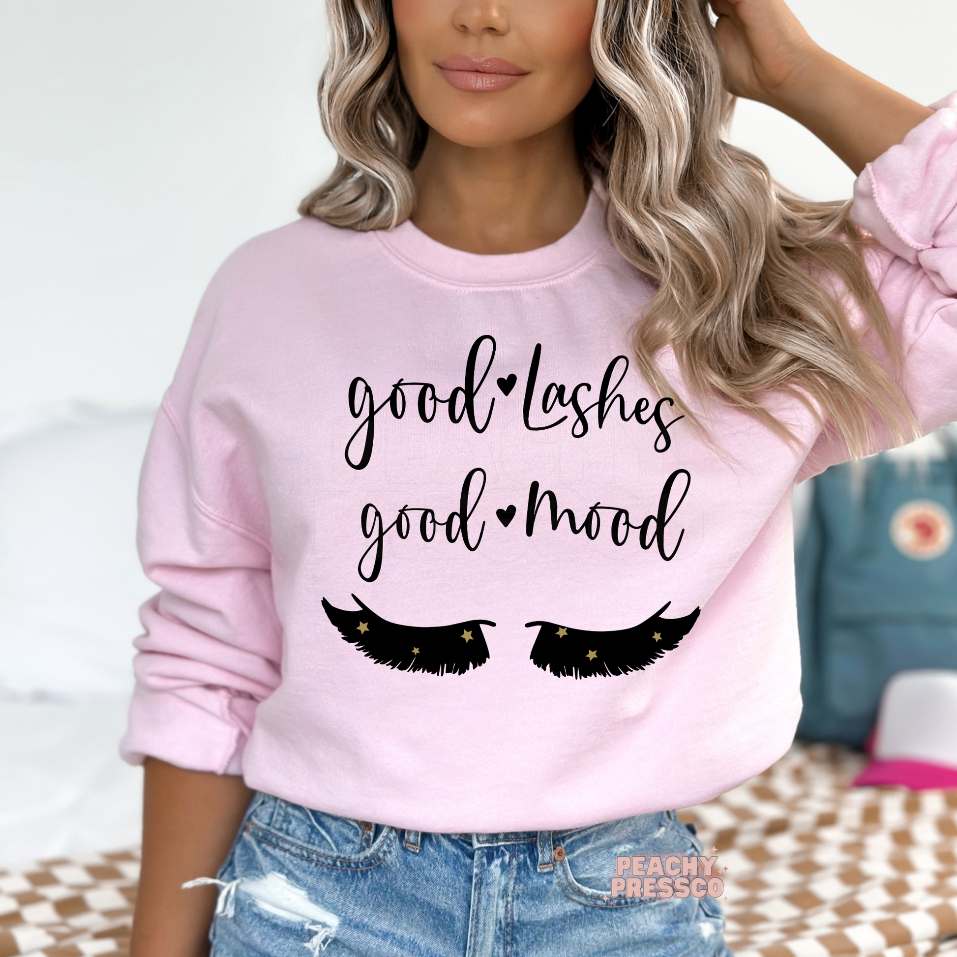 Soft pink crewneck sweatshirt featuring the Good Lashes Good Mood quote with eyelash artwork, a stylish gift for lash artists, estheticians, and beauty lovers.