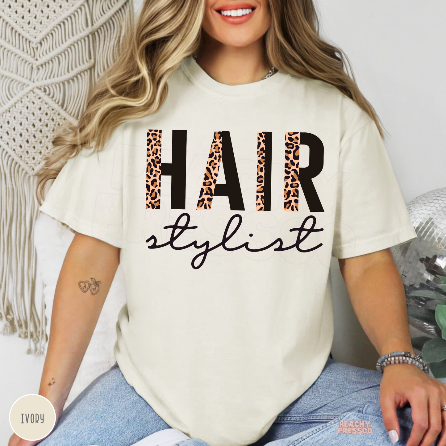 Ivory unisex t-shirt with a modern leopard print Hair Stylist graphic, a stylish gift for hairstylists, salon owners, beauty professionals, and cosmetologists.
