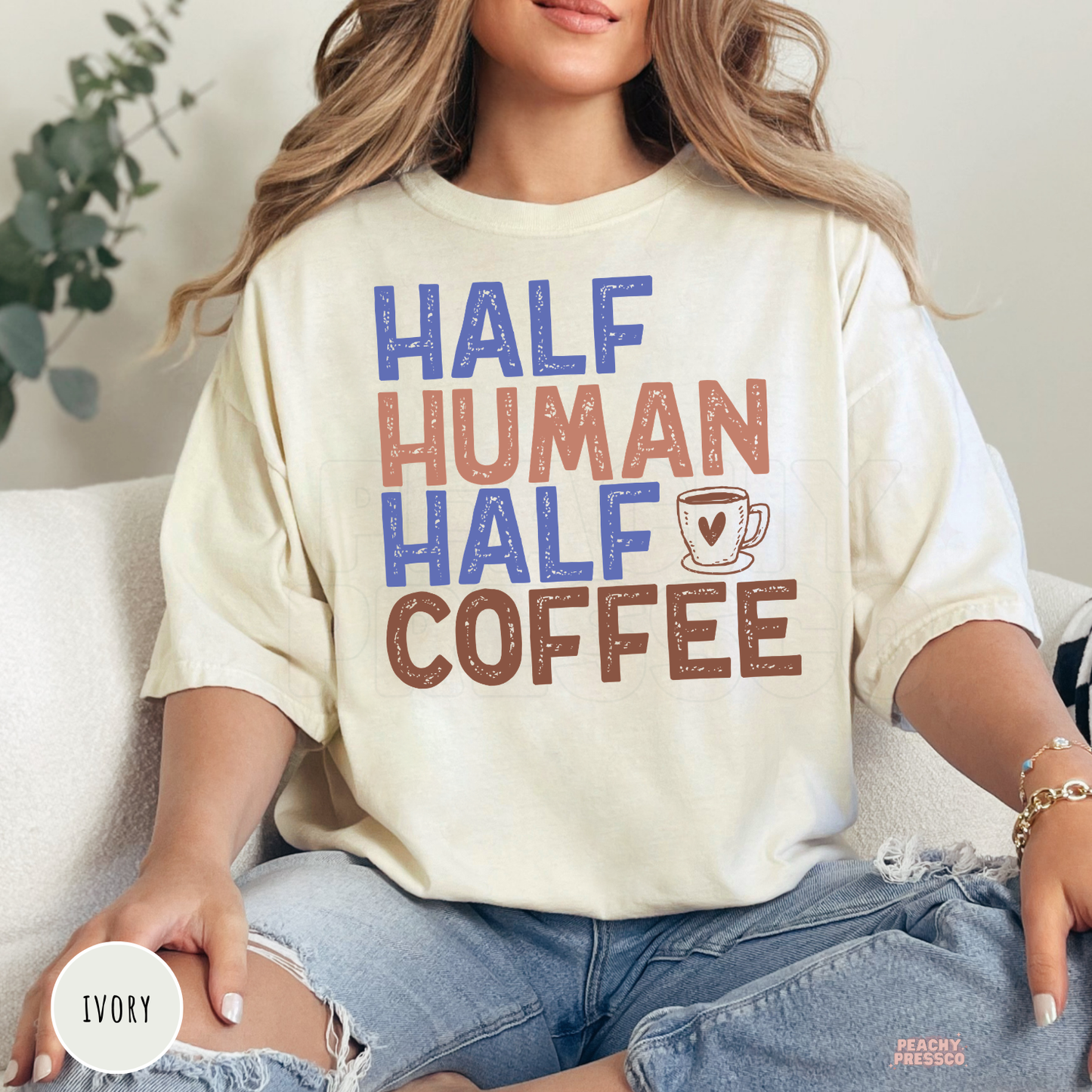 Ivory graphic t-shirt with the humorous "Half Human Half Coffee" design and coffee mug illustration for caffeine lovers.
