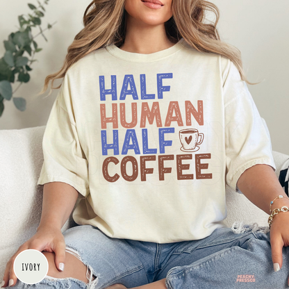 Ivory graphic t-shirt with the humorous "Half Human Half Coffee" design and coffee mug illustration for caffeine lovers.