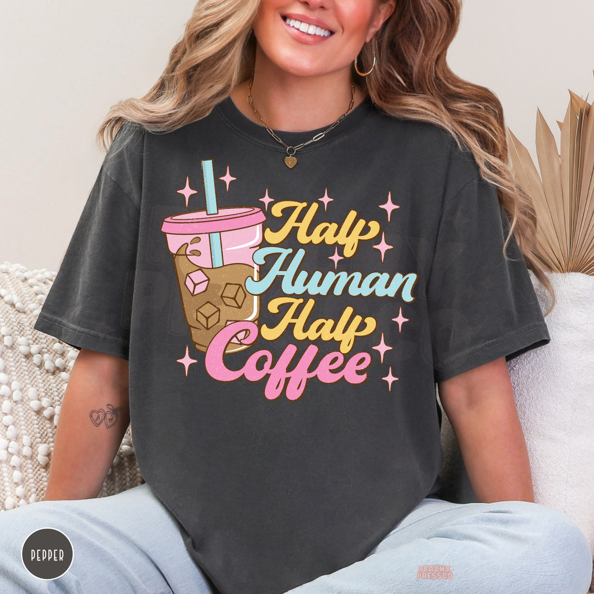 Pepper Half Human Half Coffee graphic tee with a pink iced coffee tumbler, retro lettering and playful pastel sparkles.