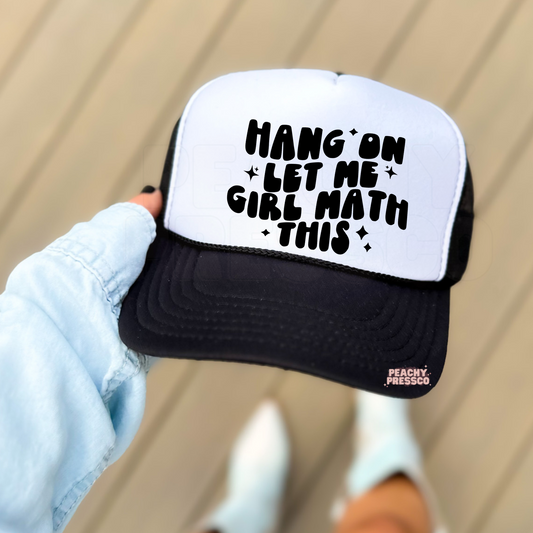 Black and white foam trucker hat with the humorous "Hang On Let Me Girl Math This" graphic in bold black text. Cute trendy hat for women, gifting, shopping trips, concerts, and casual outfits.
