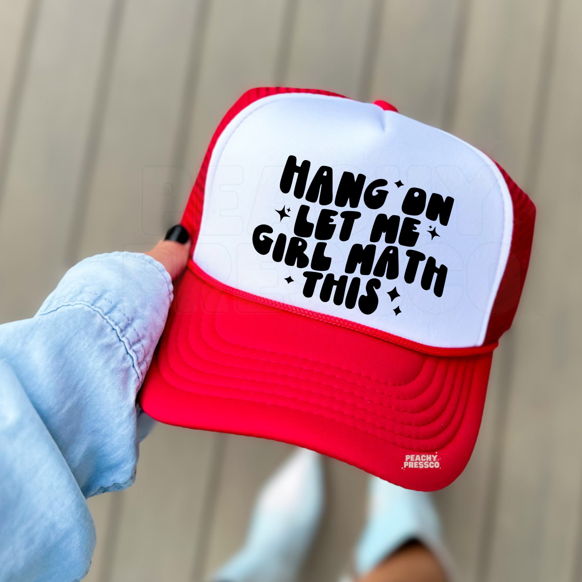 Red and white foam trucker hat featuring the funny "Hang On Let Me Girl Math This" saying in bold black lettering. Cute trendy women's baseball cap for vacations, girls' trips, shopping, and everyday style.