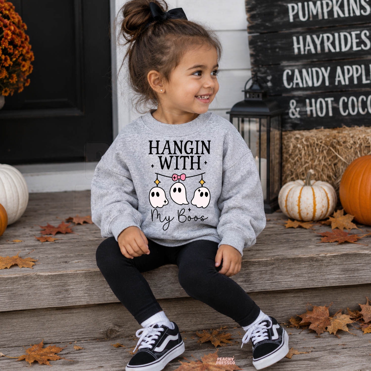 Girl wearing a sport grey Hangin With My Boos Halloween sweatshirt featuring three cute ghosts and a pink bow.