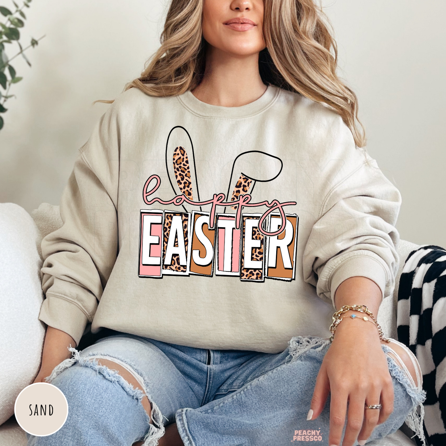 Sand crewneck sweatshirt with a Happy Easter graphic featuring leopard print bunny ears and pastel lettering.