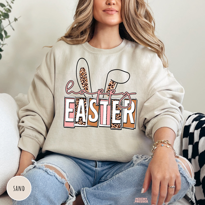 Sand crewneck sweatshirt with a Happy Easter graphic featuring leopard print bunny ears and pastel lettering.