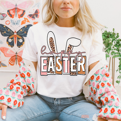 White t-shirt featuring a Happy Easter graphic with leopard print bunny ears and pink spring lettering.