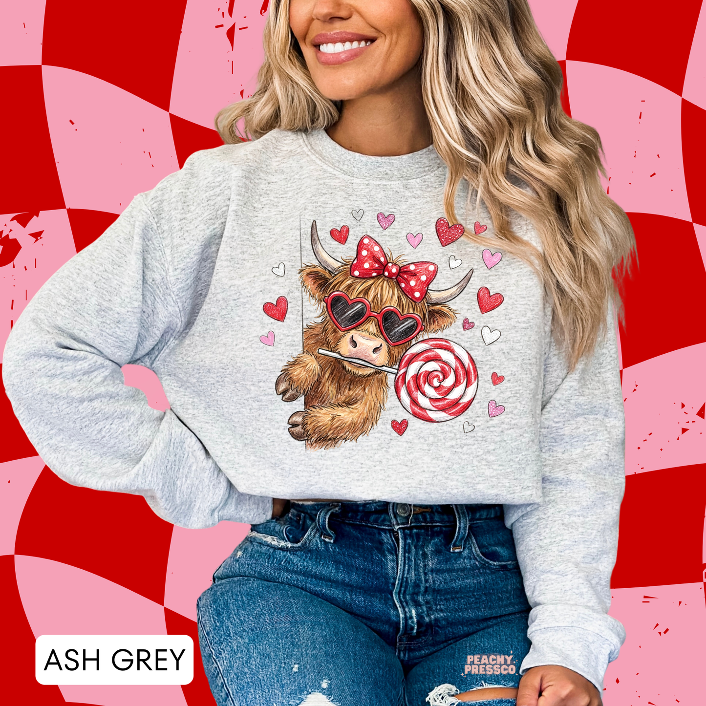 Ash grey sweatshirt with a whimsical Valentine's cow graphic featuring oversized heart sunglasses, a swirl lollipop, and pink and red hearts.