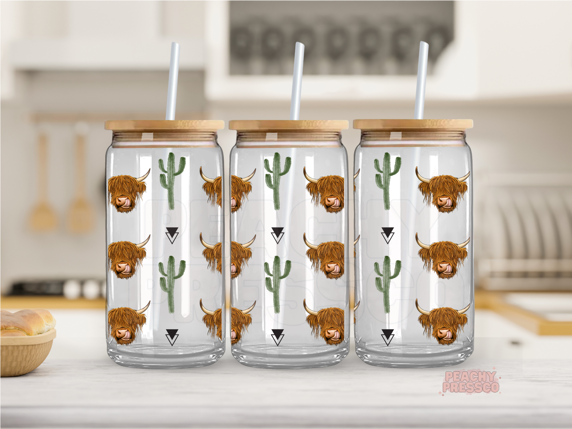 glass cup with a bamboo lid and a straw, each decorated with a cartoon illustration of a highland cow and cactus.