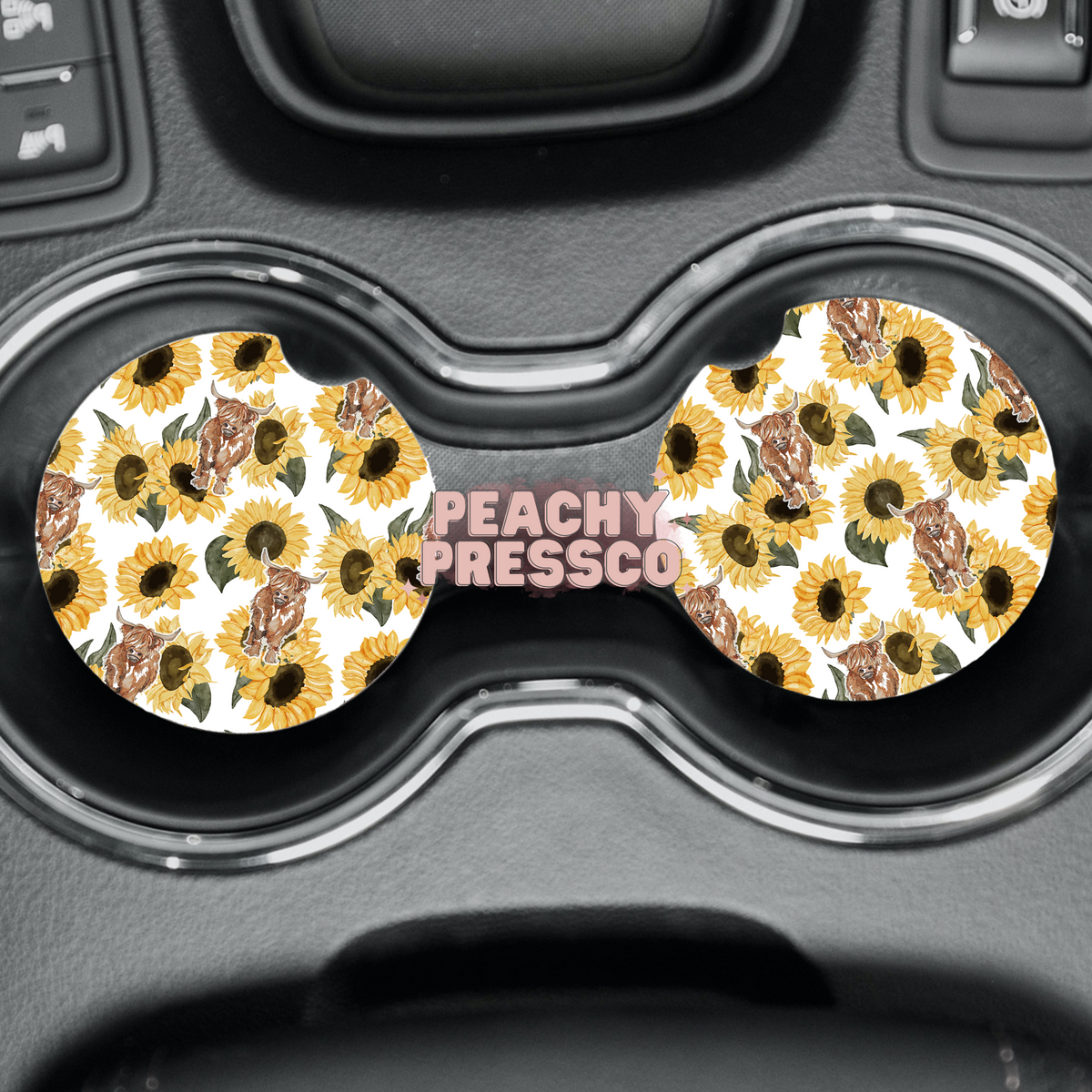 Highland cow and sunflower ceramic car coasters displayed in vehicle cup holders.