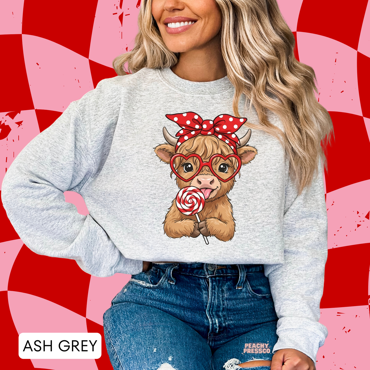 Ash grey sweatshirt featuring a kawaii Highland cow with heart-shaped glasses, a red bow, and a swirl lollipop, perfect for Valentine's Day.