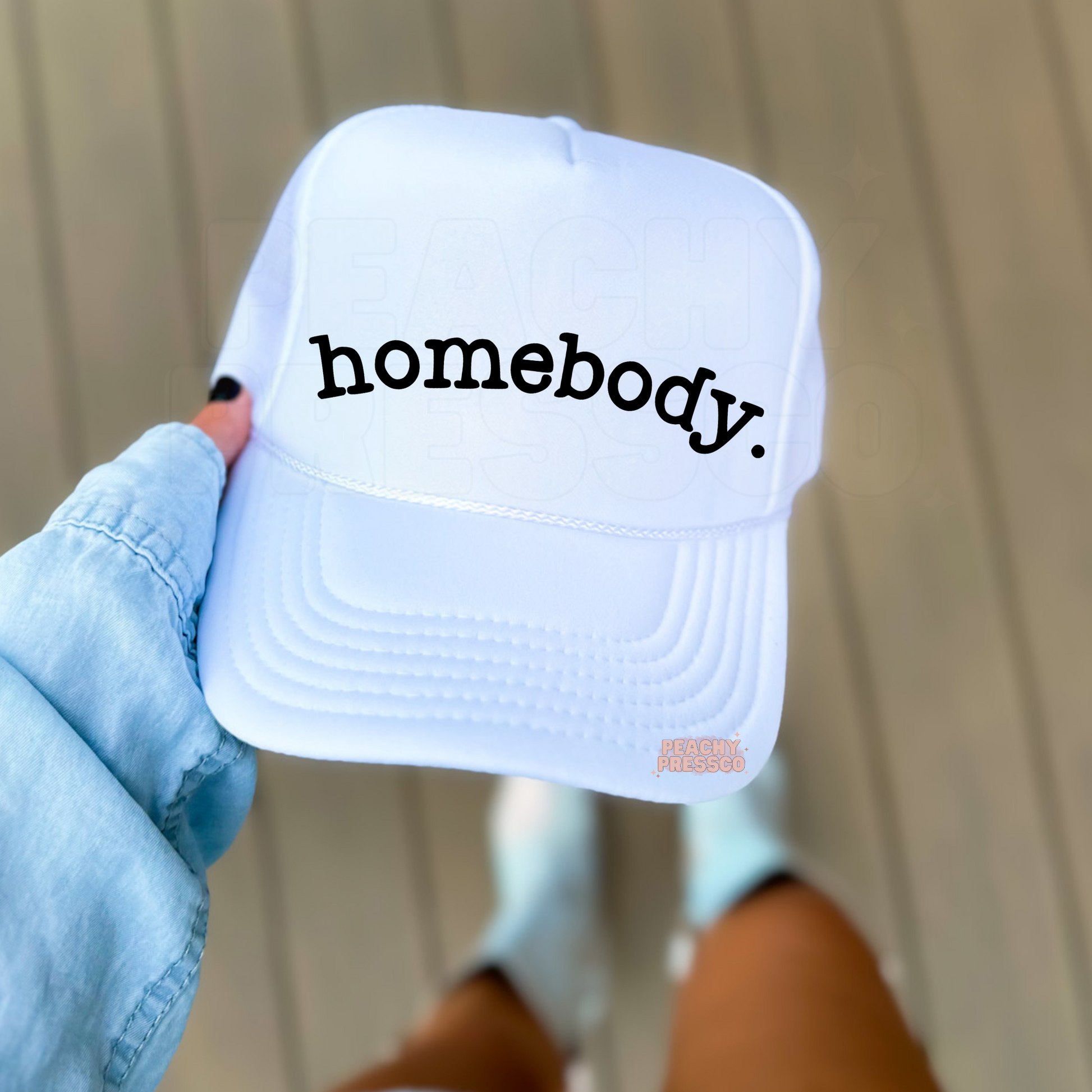 White foam trucker hat featuring the word "Homebody" in black minimalist lettering. Trendy women's trucker cap perfect for cozy days, staying in, book lovers, coffee runs, and casual everyday wear.