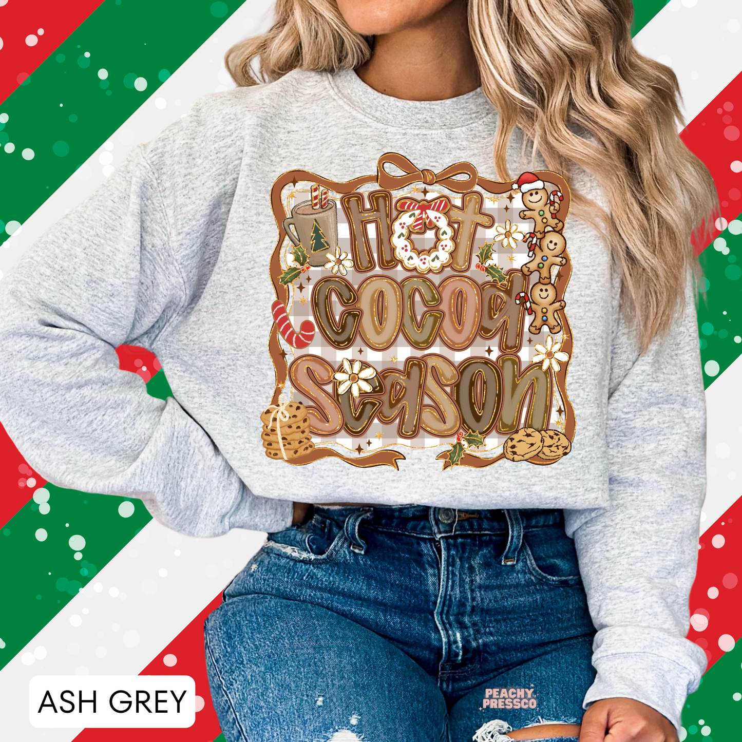 Woman posing in an ash grey holiday crewneck sweatshirt featuring a Hot Cocoa Season gingerbread design tucked into jeans.